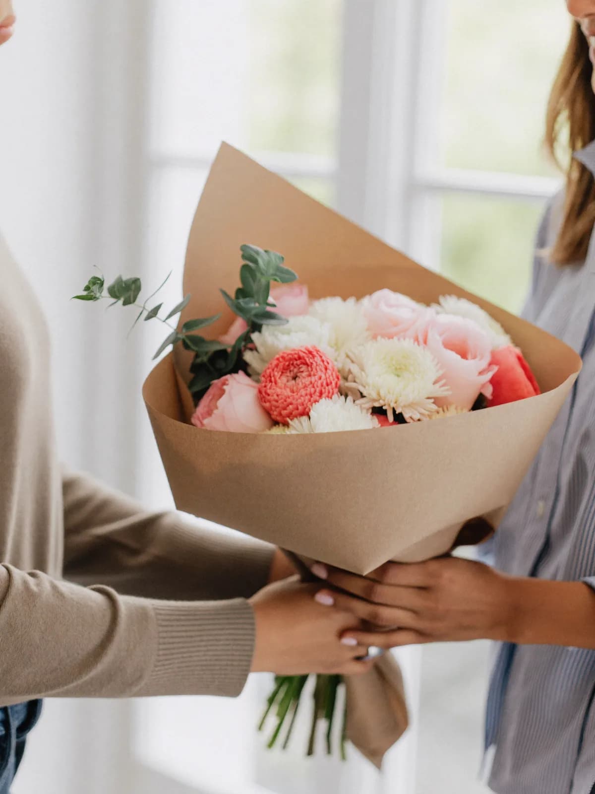 Hender som gir bort en bukett blomster